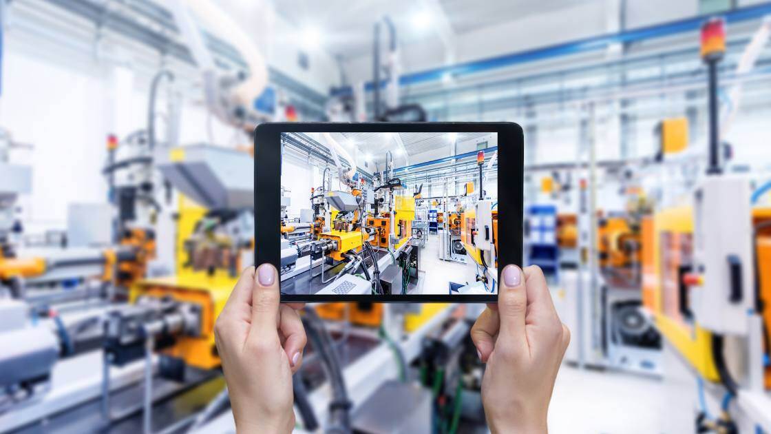 Bild einer Fabrik mit Ausrüstung und einem Tablet, das die Geräte widerspiegelt.